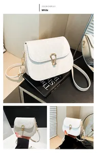 Détail du sac blanc en cuir à relief serpent avec une boucle dorée en forme de goutte