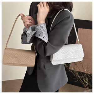 Detail of woven texture flap bags in white and khaki with gold-tone hardware detail