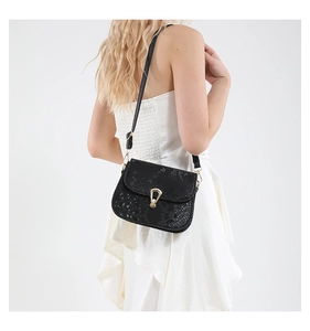 Détail du sac bandoulière noir texture serpent avec boucle dorée en goutte d'eau