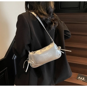 Detail of silver shoulder bag showing metallic PU texture and side bowknot decorative knots