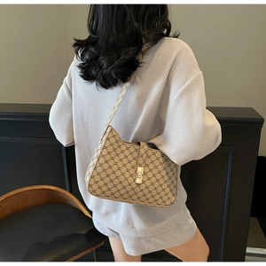 Vista dettagliata della borsa a spalla vintage con monogramma e chiusura dorata