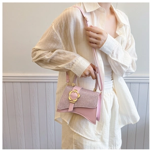 Dettaglio borsa a mano rosa con patchwork glitterato e chiusura a fiore dorato