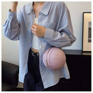 Dettaglio della borsa a sfera rosa con trama glitterata e tracolla a catena d'oro