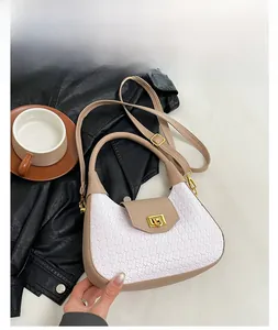 Detail view of woven leather bag in white and khaki with a gold metallic square clasp