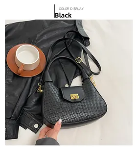 Detail of black woven texture handbag with golden square twist lock and fine stitching
