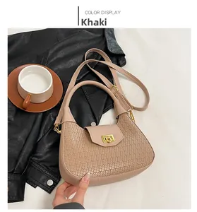 Detail view of khaki hobo bag with woven texture, golden lock and shoulder strap