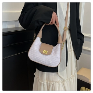 Detail of woven texture shoulder bag with leather flap and gold-tone metal twist lock