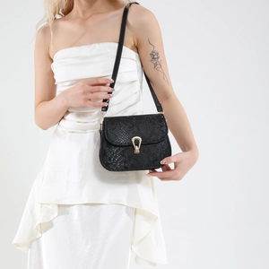 Chic black saddle bag with snakeskin texture and golden horseshoe buckle for women