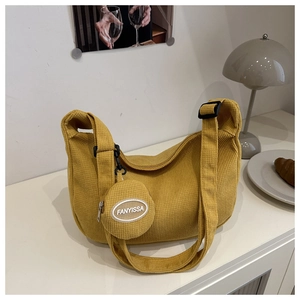 Detail of yellow corduroy hobo bag with adjustable strap and small round coin purse