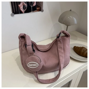 Detail of pink corduroy dumpling bag featuring a small round coin purse and soft texture