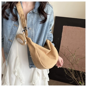 Detail of khaki corduroy crescent bag with round coin purse and logo on model