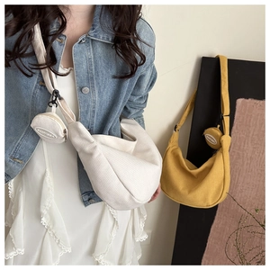 Detail of corduroy crescent crossbody bag with detachable round coin purse charm