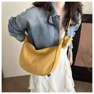 Macro detail of yellow corduroy dumpling bag with matching small round pouch on a strap