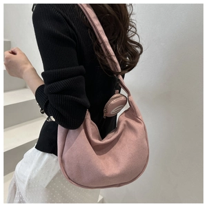 Detail of pink corduroy crescent bag with matching round pendant pouch and textured fabric