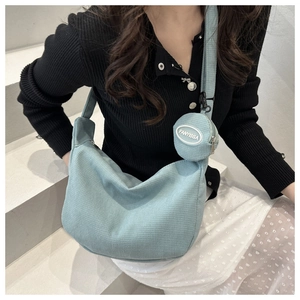 Detail of light blue waffle texture hobo bag with matching round coin purse attachment