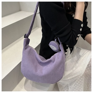 Detail of purple corduroy crescent tote bag with matching round coin purse on shoulder strap