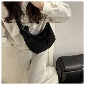 Detail of black corduroy crescent bag with matching small round coin purse on shoulder strap
