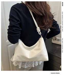 Détail d'un sac hobo blanc avec bandoulière à nœud et boucles métalliques dorées chic