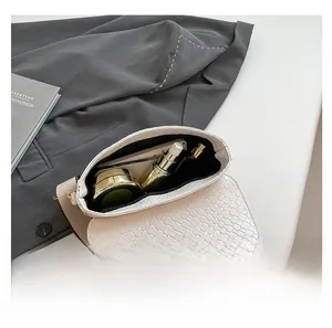 Top view of white faux crocodile texture bag interior showing phone and cosmetic space
