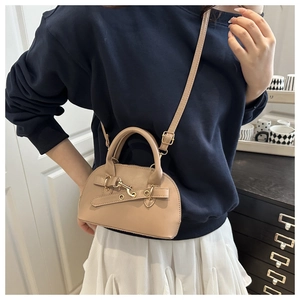 Modella che indossa borsa a mezzaluna beige con manici e dettagli in fibbia dorata