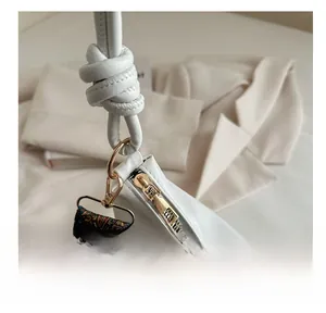 Gros plan détaillé de la fermeture éclair dorée et du cuir de ce sac fourre-tout blanc