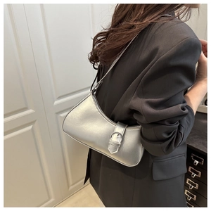 Details der silbernen Hobo-Schultertasche mit Schnallenriemen auf schwarzem Blazer
