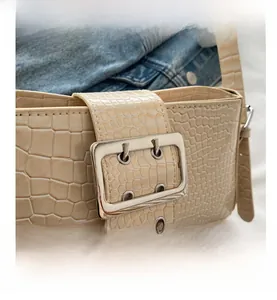 Detail showing cream faux crocodile texture with large silver rectangular metal buckle