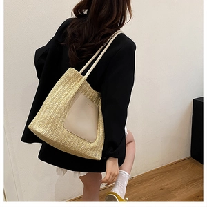 Grand sac cabas en paille tissée avec empiècement cuir porté par un mannequin