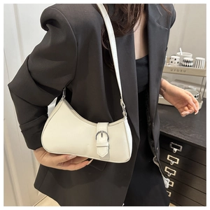 Detail der weißen PU-Unterachseltasche mit Silberschnalle über dunklem Blazer