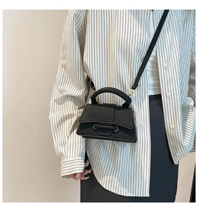 Detail of black textured hourglass handbag with a unique trapezoid silhouette