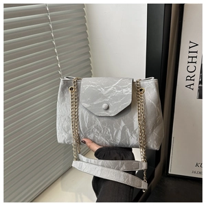 Détail du sac à bandoulière gris clair à texture froissée et chaîne dorée