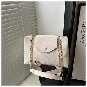 Détail du sac bandoulière blanc cassé avec texture marbrée et chaîne dorée