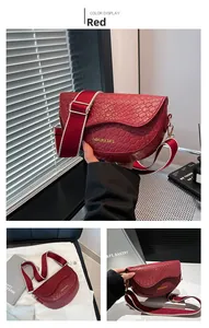 Macro shot of red saddle bag with woven texture and a wide colorful strap