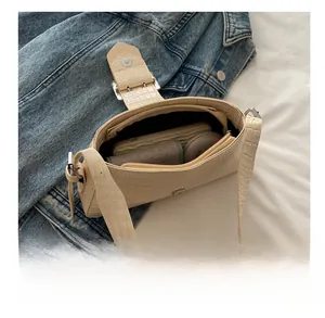 Detail view of the beige crocodile embossed shoulder bag interior and its daily capacity