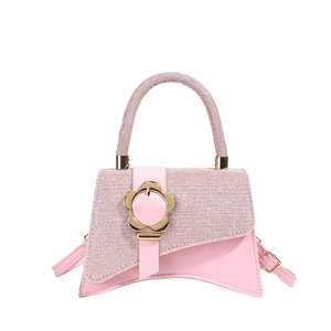 Petit sac à main rose pailleté avec base incurvée et boucle fleur dorée sur fond blanc
