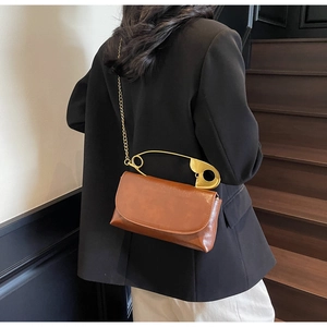 Détail du sac bandoulière marron-rouge avec poignée épingle dorée et bandoulière