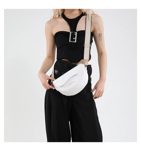 Detail of white saddle bag showing crocodile texture and adjustable wide strap