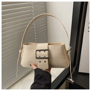Close-up of cream white crocodile embossed shoulder bag with large silver square buckle detail