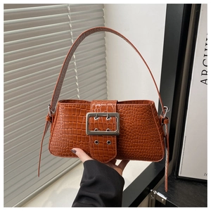Close-up of brown crocodile embossed faux leather shoulder bag with large silver buckle