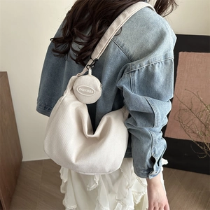 Stylish cream corduroy shoulder bag set with a small round pouch shown on a model