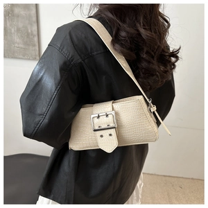 Cream baguette bag with crocodile texture and silver buckle worn on person shoulder