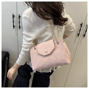 Détail du sac bandoulière rose pâle avec texture marbrée porté par un mannequin
