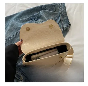 Internal view showing the capacity of the cream crocodile embossed saddle crossbody bag