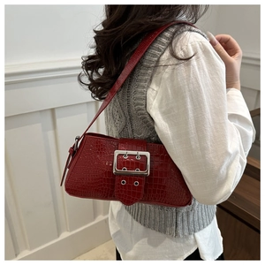Macro detail of red crocodile embossed leather with silver buckle on shoulder bag