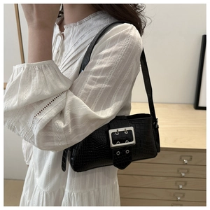 Detail of black crocodile texture shoulder bag with large silver rectangular metal buckle