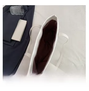 Détail du grand sac cabas blanc avec doublure en tissu marron foncé et fermeture éclair