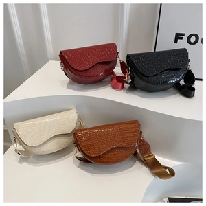 Detailed view of four crocodile pattern saddle bags in red, black, beige, and brown colors