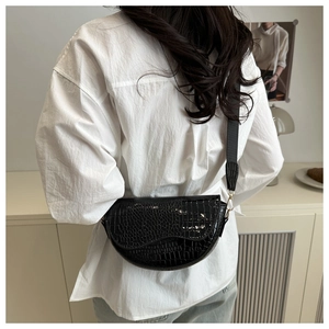 Detail showing high-quality black faux leather with embossed crocodile texture on saddle bag