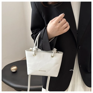 Mini borsa bianca con dettaglio manico annodato su blazer nero per un contrasto raffinato