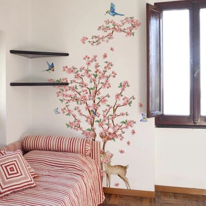 Detail of pink floral wall stickers featuring cherry trees, blue birds and a cartoon deer